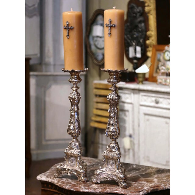 Commanding in scale and rich in devotional symbolism, this pair of antique church candlesticks brings dramatic...