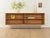 Classic sideboard from the 1960s. Body in oak veneer with two shelves and new square steel feet in white. The top was...