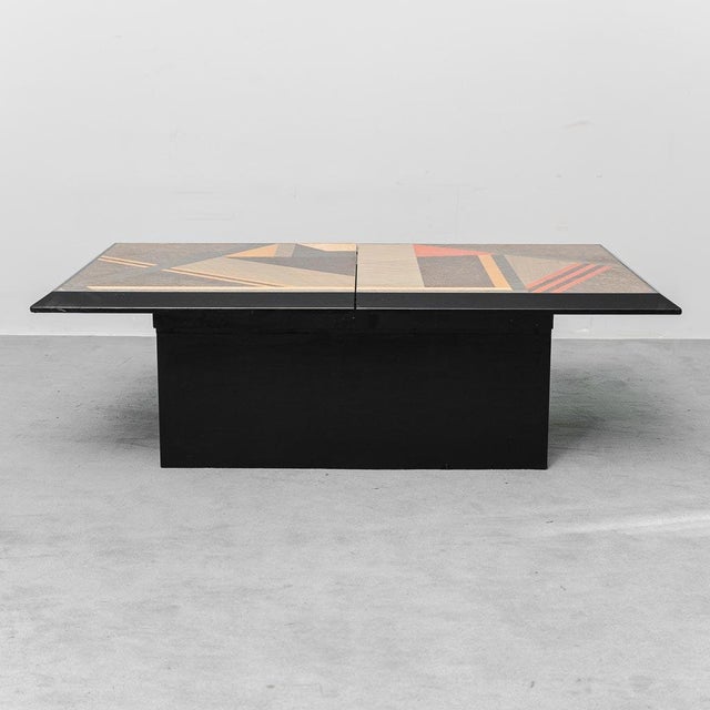 Coffee table from the 1970s. Black wooden frame with a multicolored fold-out top. with a storage compartment. Good...