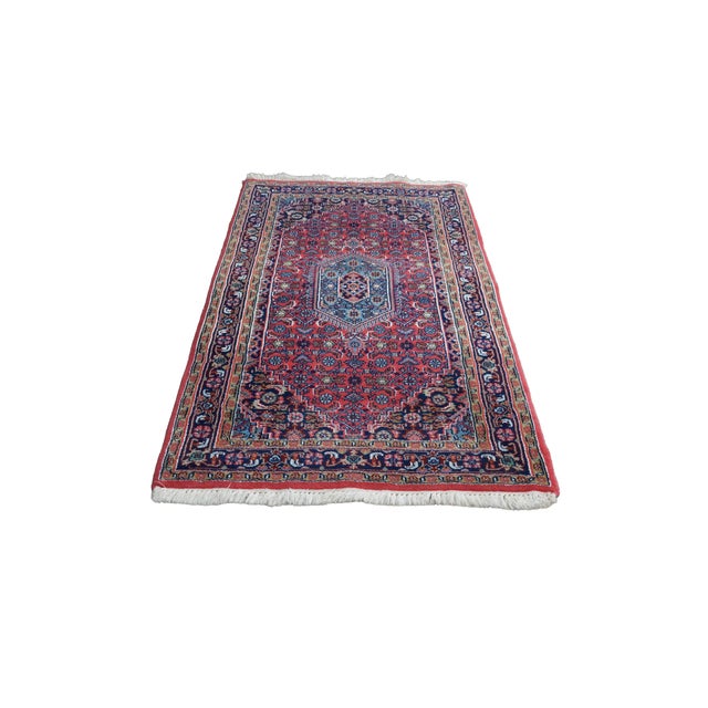This vintage hand-knotted wool scatter rug showcases a classic geometric and floral medallion design rendered in a bold,...