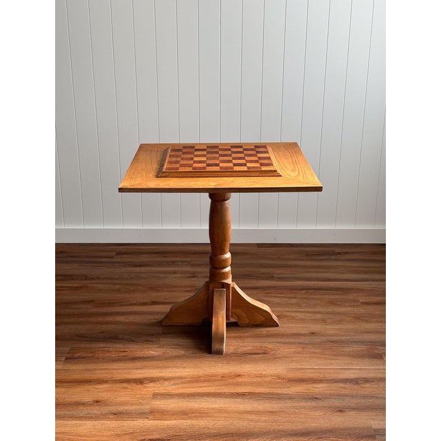 A mid-20th-century American game table crafted from solid oak, featuring a parquetry inlaid chessboard set into a square...