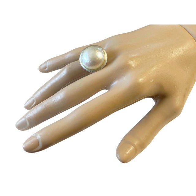 This superb 18k white gold ring showcases a Mabe pearl encircled by a brushed gold frame, measuring 0.75" in diameter and...