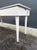 White lacquered wood kitchen table with a white marble top with gray veining. The table is rectangular, with a large...