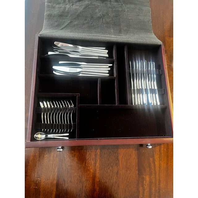 Elegant Christofle flatware set presented in its original wooden storage chest. This is an incomplete set that has never...