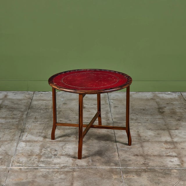Leather-top occasional table features a deep red leather inset top with floral gold-tooling around the scalloped rim. The...
