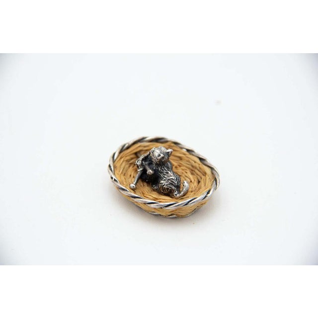 Miniature silver cat lying in a basket. Metal: Silver Origin: Italian Brand: Arezzo Weight: 12.13 grams Dimensions: 3.8cm...