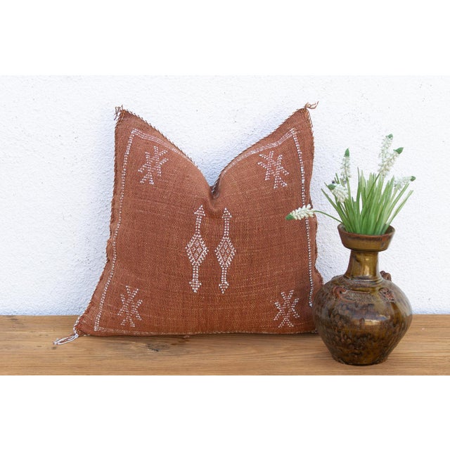 Stacked diamonds trail down the center of this handcrafted Moroccan cactus silk pillow, echoed by star motifs at each...