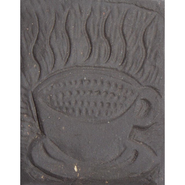 A studio pottery tile by the American artist Mark Bulwinkle (born 1946). This tile black in color and features the stamped...