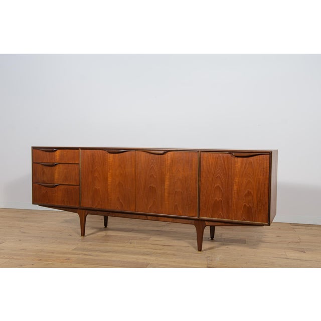 This mid-century sideboard in teak was produced in Great Britain, designed Tom Robertson to Mcintosh in the 1960s. The...