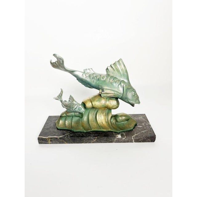 Decorative French sculpture dating from the 1950s, depicting two stylized fish swimming above sculpted waves and rocks....