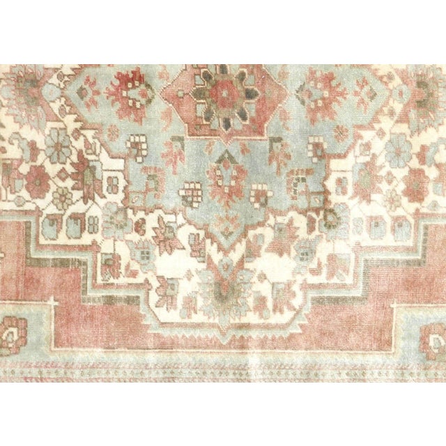 This vintage Turkish Oushak rug, measuring 4'11" by 10'2", is handwoven with wool on a wool foundation in Western Turkey's...