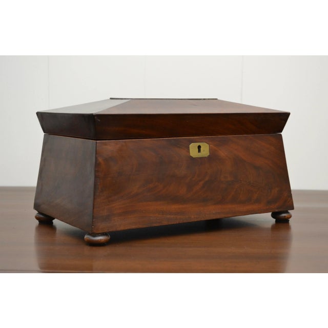 A 19th c English flame mahogany sarcophagus with three lidded compartments. Of Regency style with a simple neoclassical...