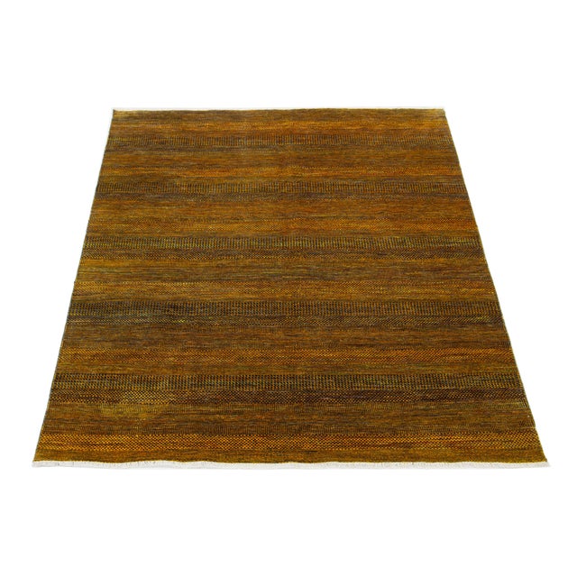 This elegant hand-knotted wool rug features a contemporary design. It showcases a meticulously crafted field in goldenrod,...