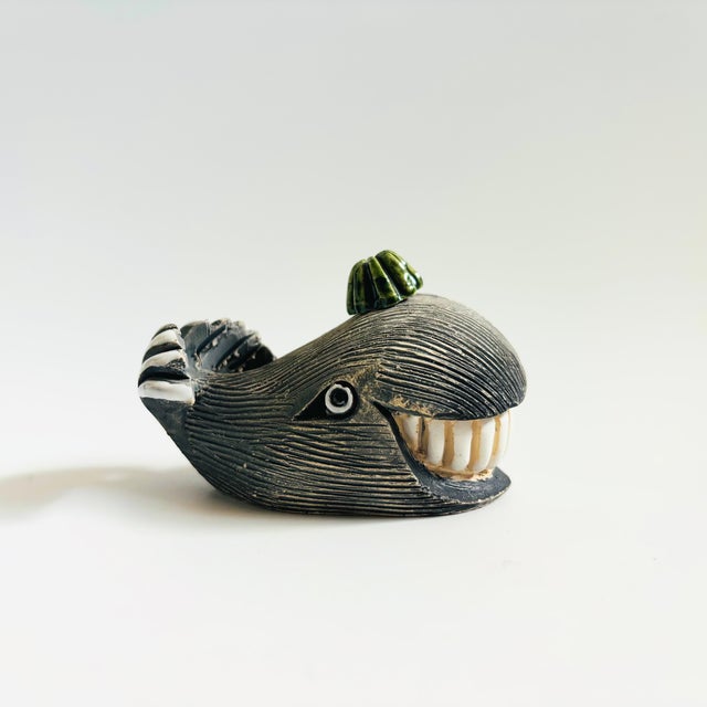 A vintage pottery whale with a little green hat and a big smile. Made in Uruguay by Artesania Rinconada. Great hand...