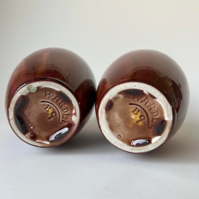 A striking pair of antique English art pottery vases from Stoke-on-Trent. Featuring a high-gloss drip glaze in burgundy...