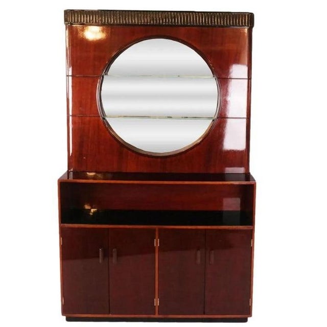 Art Deco style mahogany cabinet and bar suite features a tall display cabinet with round center mirror and shelves, bar...