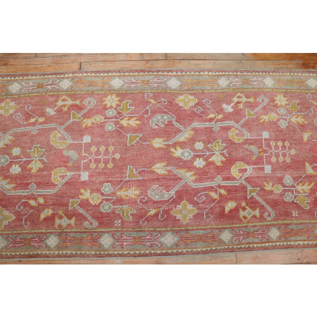 An antique Turkish oushak runner with an all-over design in a dominant soft red color, circa 1920 Measures: 2'6'' x 11'4''.