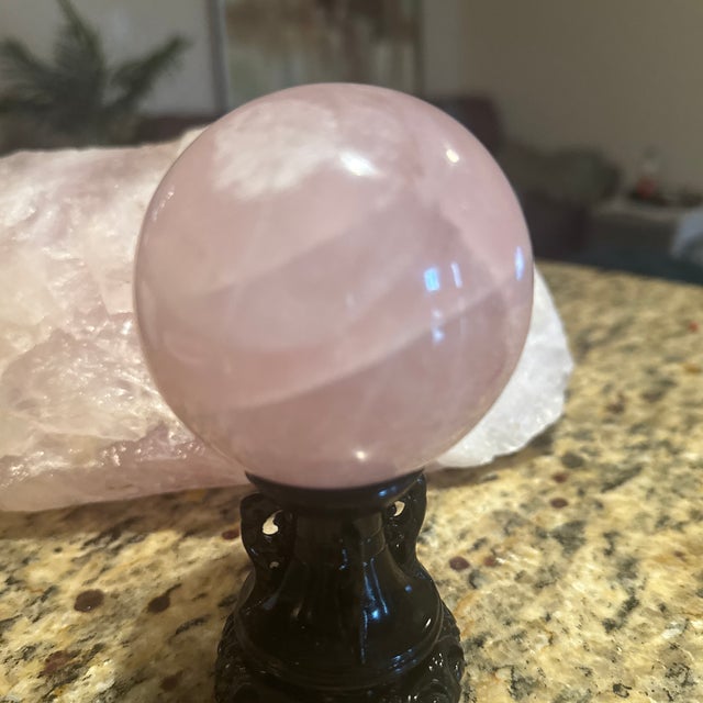 Elevate your space with this striking natural pink rose quartz crystal sphere. Meticulously polished to a glossy finish,...