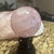 Elevate your space with this striking natural pink rose quartz crystal sphere. Meticulously polished to a glossy finish,...