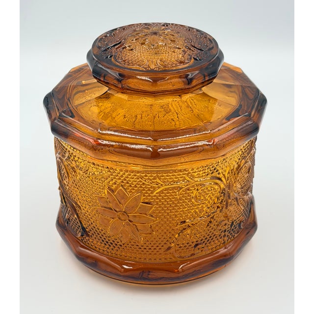 Timeless elegance of this stunning vintage Indiana Glass Tiara Amber lidded canister! This exquisite piece showcases the...