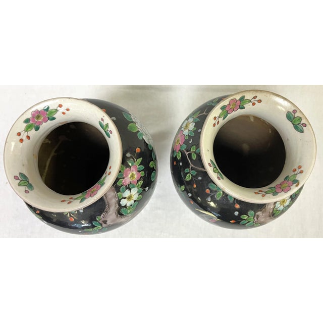 Stunning pair of Chinoiserie style hand painted porcelain vases. The classic vases depict birds and peonies in shades of...