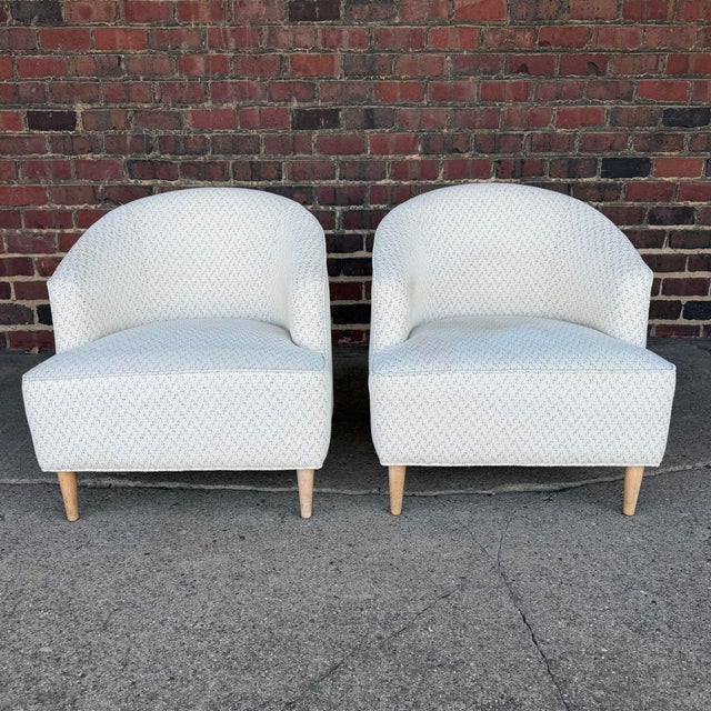 This is a pair of custom white tub chairs. They have champagne stained legs and a white speckled upholstery.