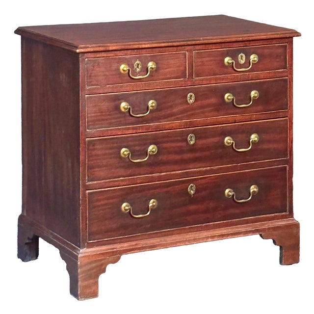 A fine English small chest or dresser cabinet of patinated mahogany from the Georgian period, featuring a moulded top over...