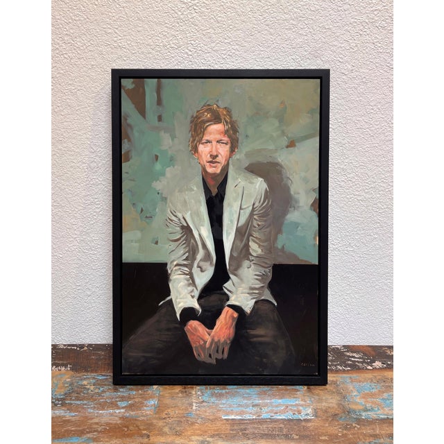 This portrait captures a seated figure with a relaxed yet introspective demeanor, dressed in a light-colored blazer...
