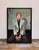 This portrait captures a seated figure with a relaxed yet introspective demeanor, dressed in a light-colored blazer...