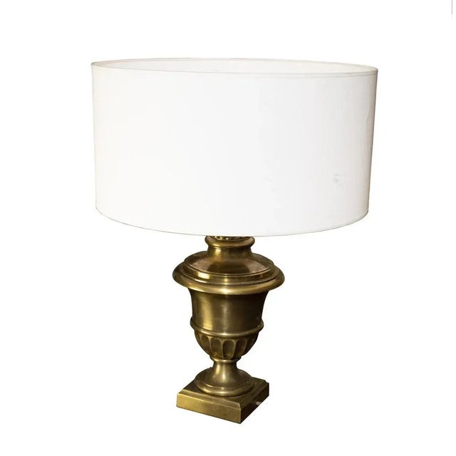 France table lamp with an hourglass-shaped structure and a rectangular base. The lampshade is made of an Off-white fabric....
