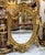 Make a grand statement with this extraordinary oval wall mirror, featuring an elaborate sculpted frame finished in radiant...
