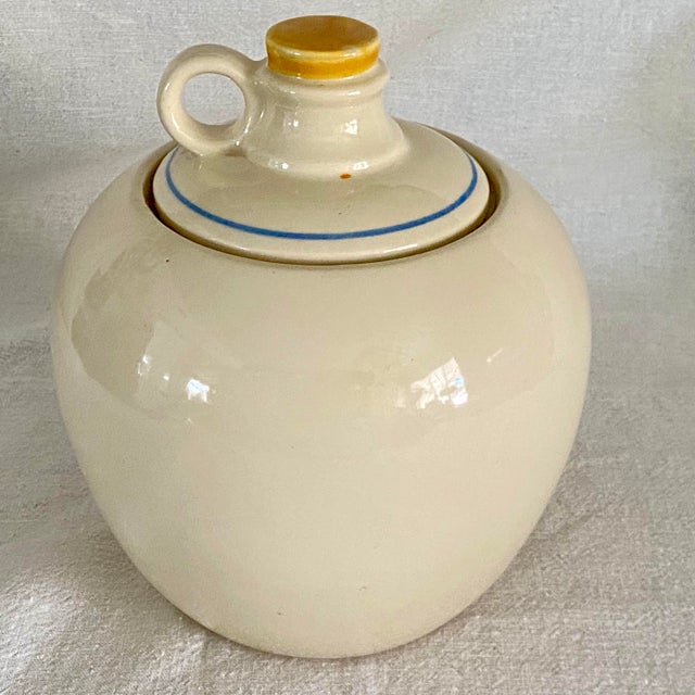 Shawnee. Pottery jar, is patterned in the shape of a whiskey jug. It has hand painted hearts and tulips found on Shawnee's...