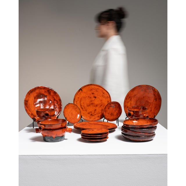 This 1970s dinnerware set from Germany is finished in burnt orange, worked in ceramic. Its signed detailing gives the...