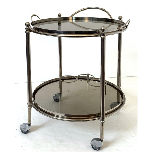 A vintage Mid-Century Modern circular bar cart table or drinks serving trolley of polished chrome from England, featuring...