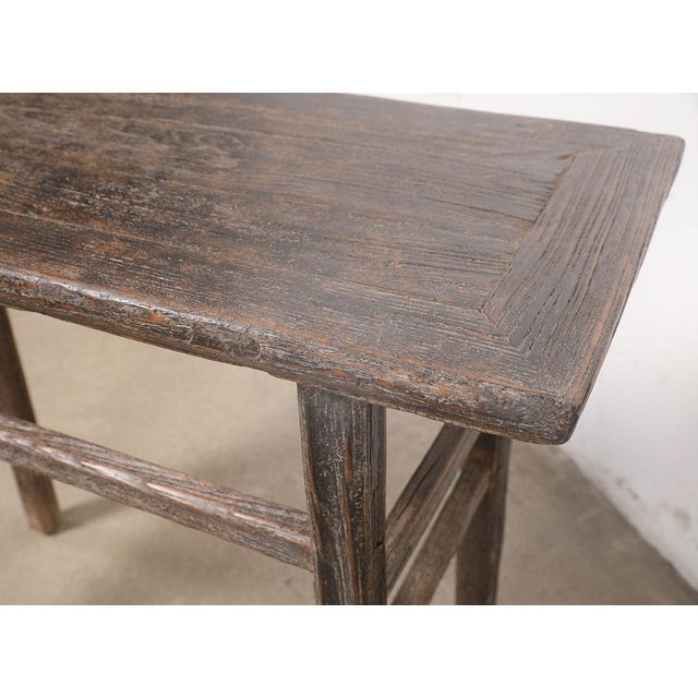 A charming rustic hall table crafted from solid elmwood, dating to the first half of the 20th century. The simple...