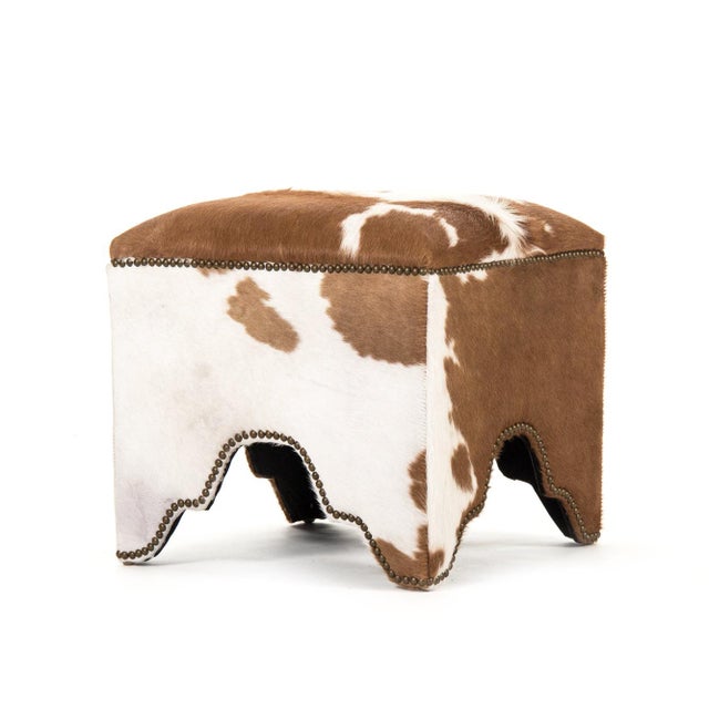 This is a stool featuring a sophisticated design with cowhide upholstery. The upholstery showcases a natural cowhide...