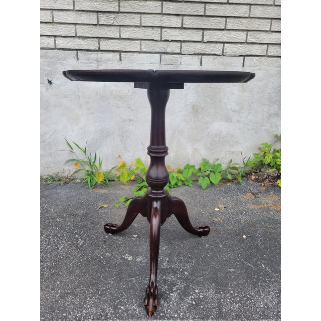 Exquisite 1930s English Chippendale piecrust mahogany table, showcasing masterful craftsmanship and timeless elegance. The...