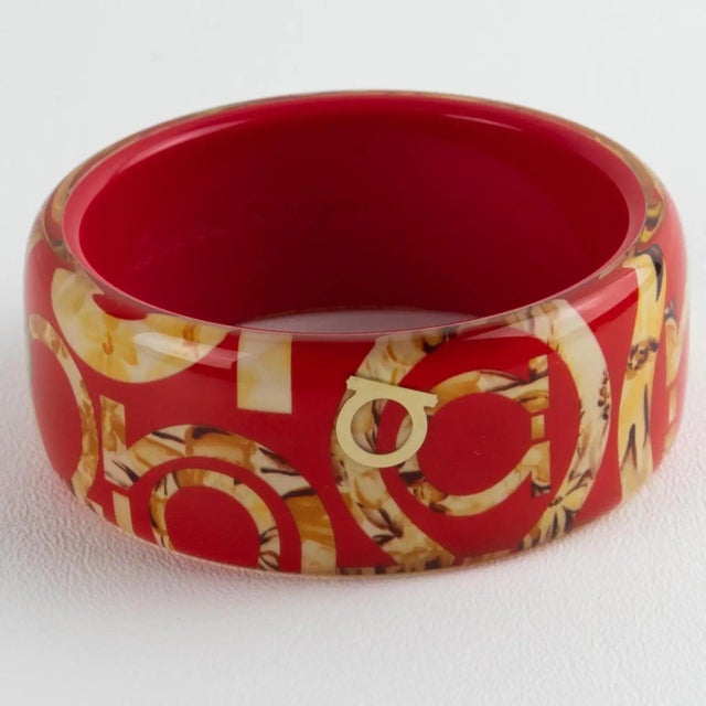 This stunning Salvatore Ferragamo, Italy bracelet features a chunky Lucite or acrylic bangle in luminous red color, ornate...