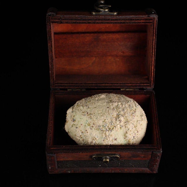 This is a rare, spherical relic cluster, described as a "regenerated sarira" (Buddhist relic). The object has a textured,...
