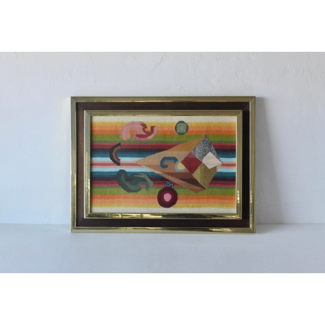This is a framed needlepoint tapestry featuring an abstract geometric design. The colorful geometric shapes and abstract...