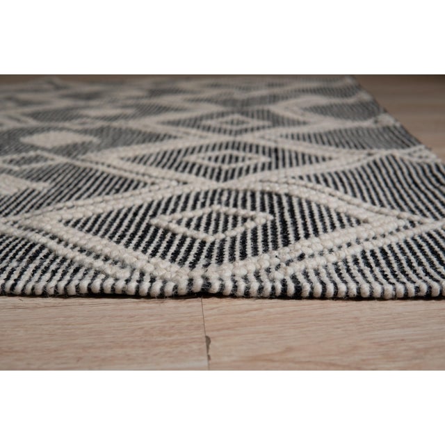 Luna Kilim Black Handmade Wool Rug, Country of Origin: India. This striking flat-woven piece showcases the enduring...