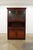 This Bassett Furniture china cabinet features a warm reddish-brown wood finish with clean traditional detailing and a...