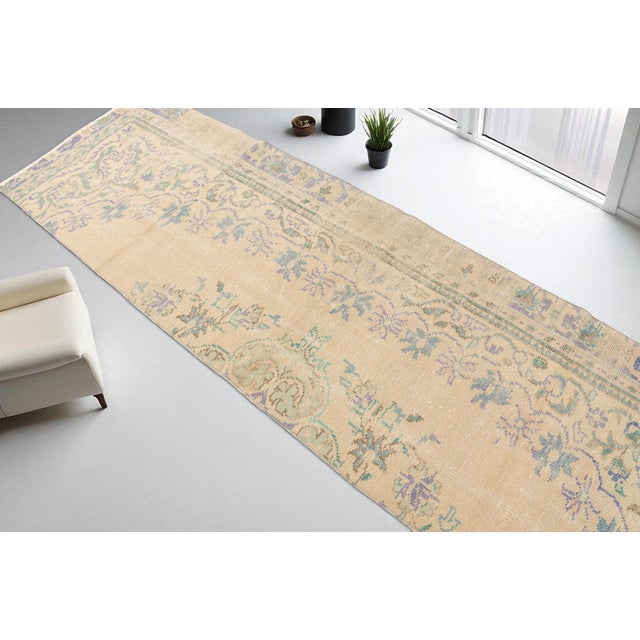 This is a vintage Turkish Oushak rug from the Mid 20th Century. The piece was hand-knotted.