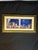 A Mediterranean coastal-style framed wall art piece featuring a dramatic night scene with deep blue tones, moonlight,...