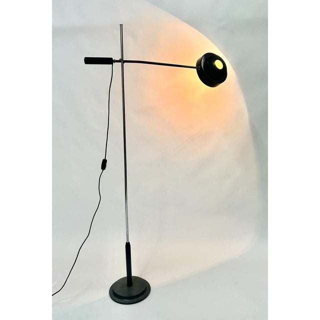 Floor lamp model "1004" designed by Gino Sarfatti for Arteluce, 1961. Perforated reflector in lacquered aluminum, with the...