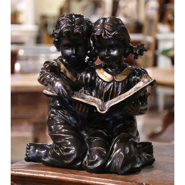 Full of charm and expressive detail, this antique French bronze sculpture depicts two young children seated closely...