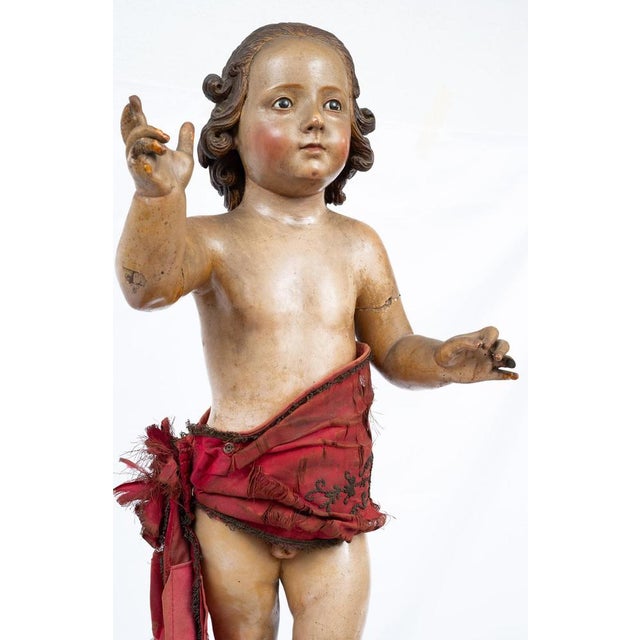 An antique Neapolitan polychrome wooden sculpture depicting a blessing child. The child has naturalistic, childlike...