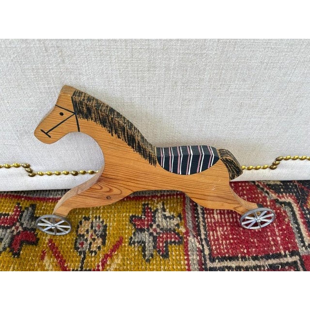 Adorable handmade vintage wooden horse with painted detail and metal wheels. This would be darling in a nursery or kids...