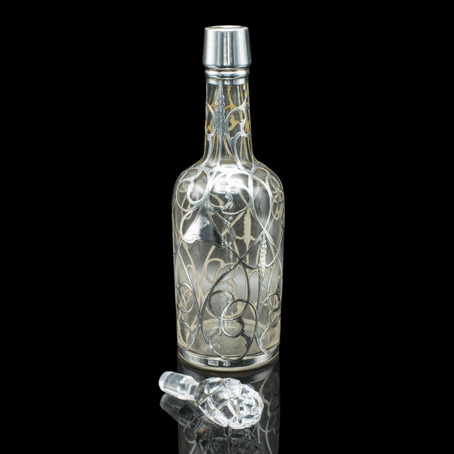 This is an antique Sherry decanter. An English, glass and silver plated spirit bottle, dating to the Edwardian period,...