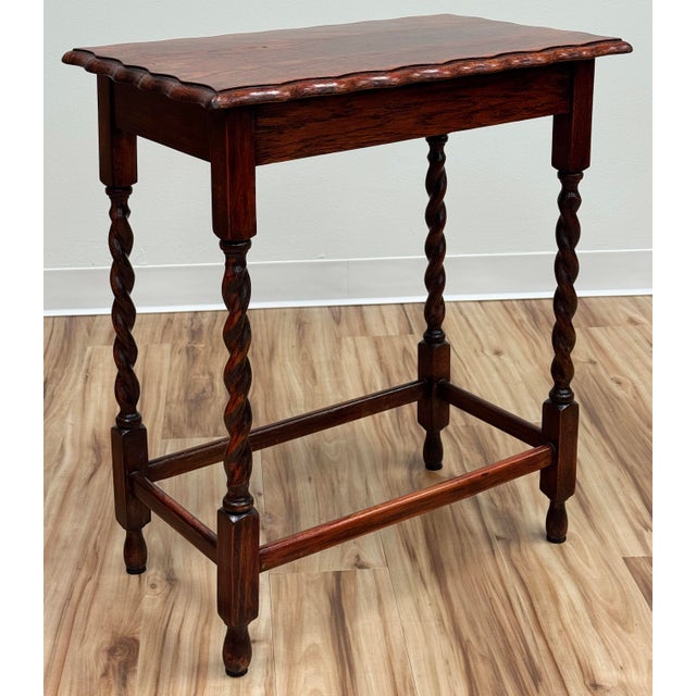Antique English oak side table with deep red stain, pie crust top and four classic barley twist legs attached by four box...